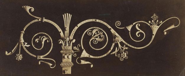 Metalwork. Elaborately ornamental door fitting is made from spiralling, swirling iron bands. One band curves to one side of a post, and the other branches into two swirls.